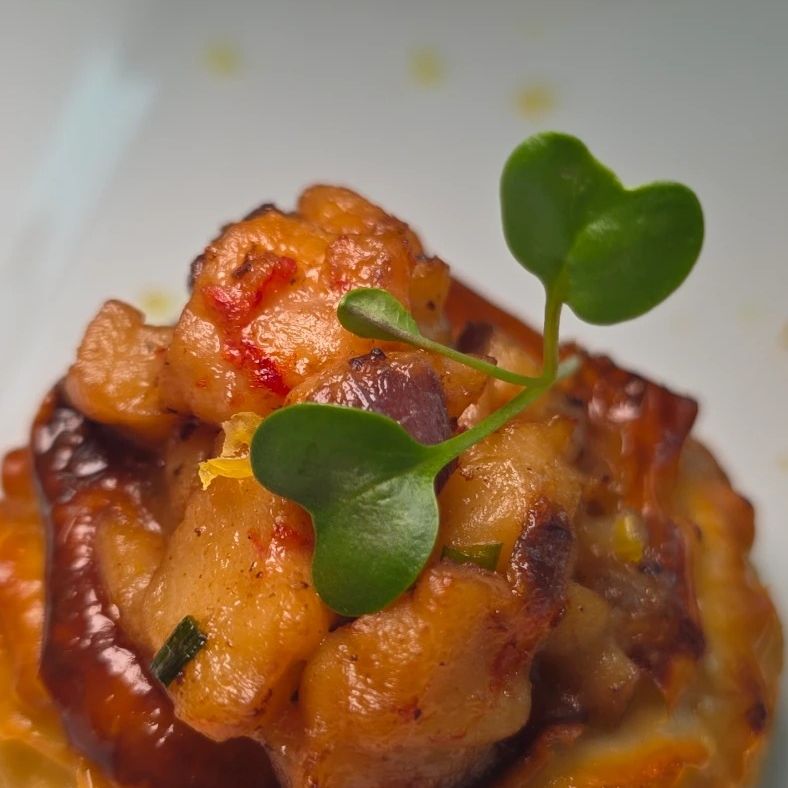 A savoury tart topped with braised meat and micro herbs