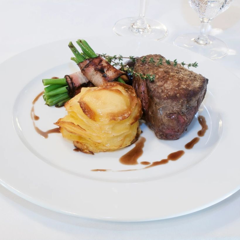 Steak with a potato terrine and green beans, plated for service